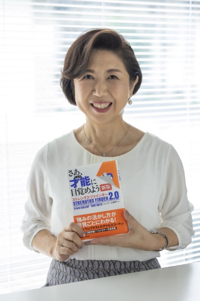 本を持って微笑む丹羽コーチ