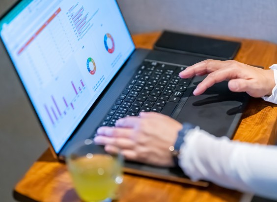 ノートパソコンでデータ分析の画面を操作する人の手元