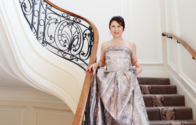 屋外で花に手を添える丹羽コーチ