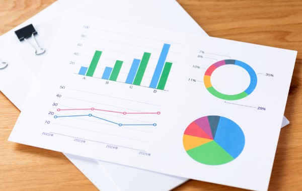 グラフの紙媒体の資料が重なって置かれている写真