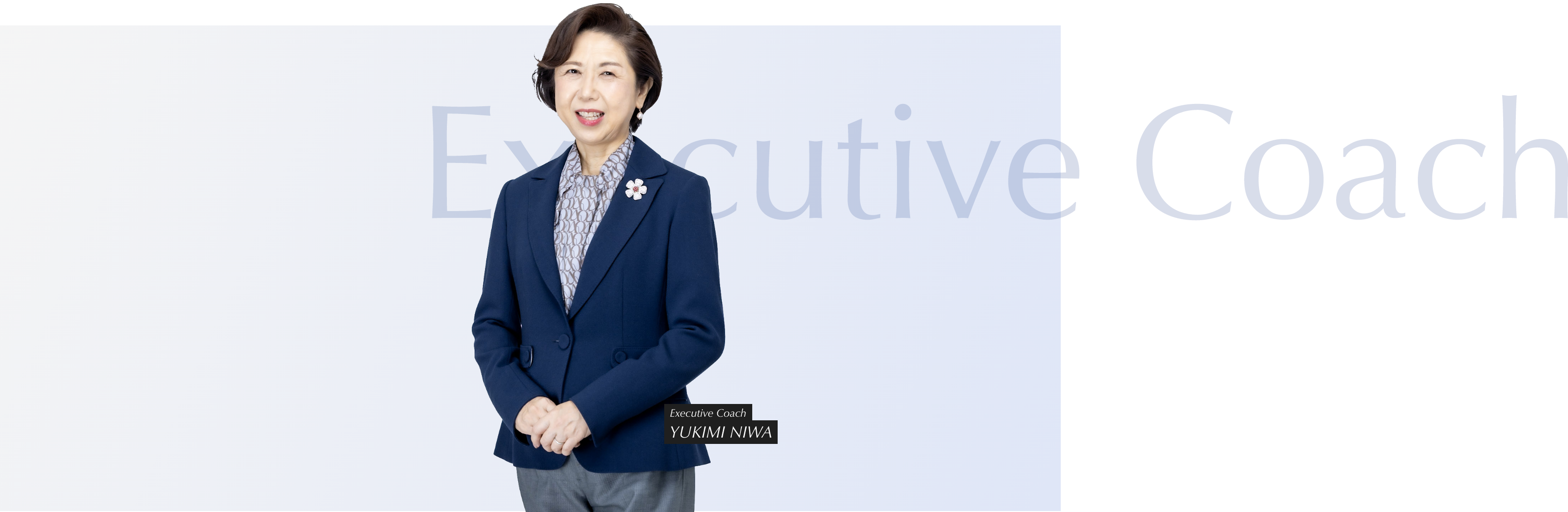 両手を前に笑顔で立っている丹羽コーチ